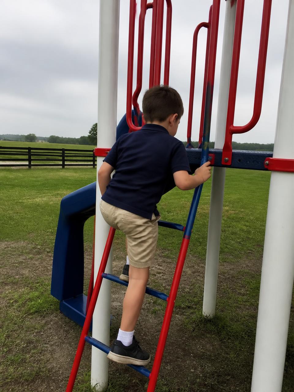 Illustration of a student in a navy school polo on the red, white and blue playground tower
